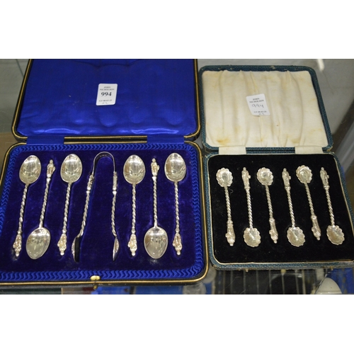 994 - Two cased sets of silver coffee spoons with apostle terminals, one set with sugar tongs.