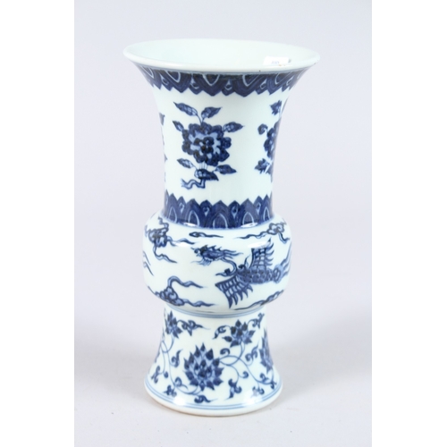 123 - A CHINESE PORCELAIN BLUE AND WHITE GU SHAPE VASE, painted with phoenix and flowers. 21.5cms high.... 