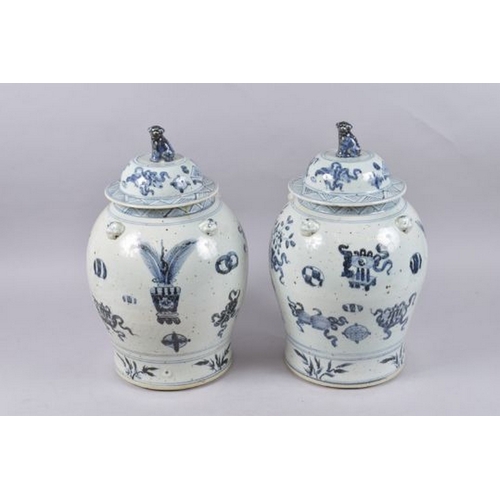 124 - A LARGE PAIR OF CHINESE BLUE AND WHITE PORCELAIN JARS AND COVERS, painted with various objects, 48cm... 