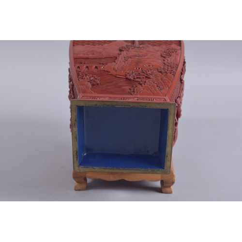 125 - A CHINESE RED CINNABAR LACQUER VASE ON WOODEN STAND, with landscape scenes and flora, 28cm high.