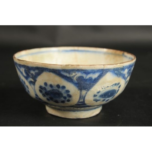 128 - AN EARLY PERSIAN BLUE AND WHITE GLAZED POTTERY BOWL, painted with floral motifs, provenance: formerl... 