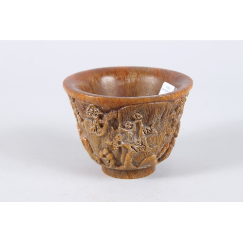 137 - A CHINESE CARVED HORN CIRCULAR BEAKER. 4.5ins diameter.
