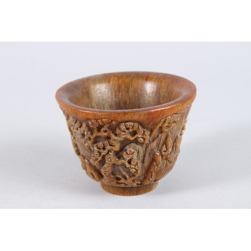 137 - A CHINESE CARVED HORN CIRCULAR BEAKER. 4.5ins diameter.