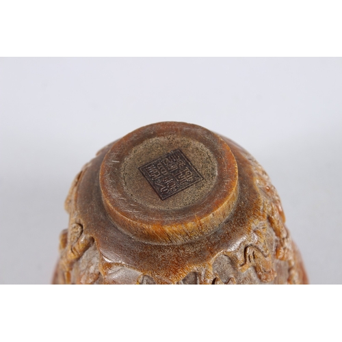 137 - A CHINESE CARVED HORN CIRCULAR BEAKER. 4.5ins diameter.