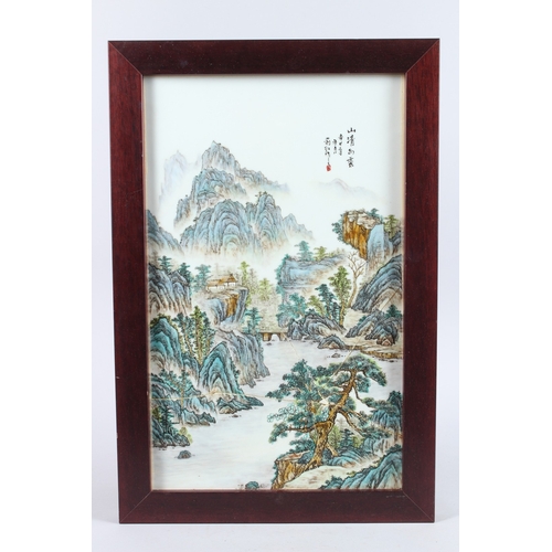 156 - AN EARLY 20TH CENTURY CHINESE PORCELAIN FAMILLE VERTE PORCELAIN PANEL, framed, painted with a mounta... 