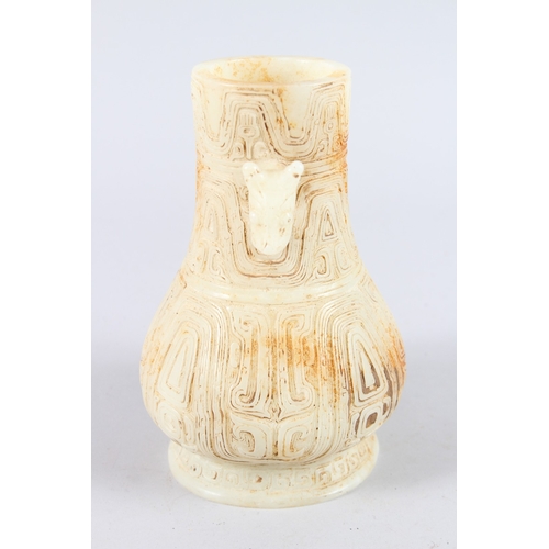 160 - A CHINESE ARCHAIC FORM CARVED JADEITE TWIN HANDLED VASE. 21cms high.