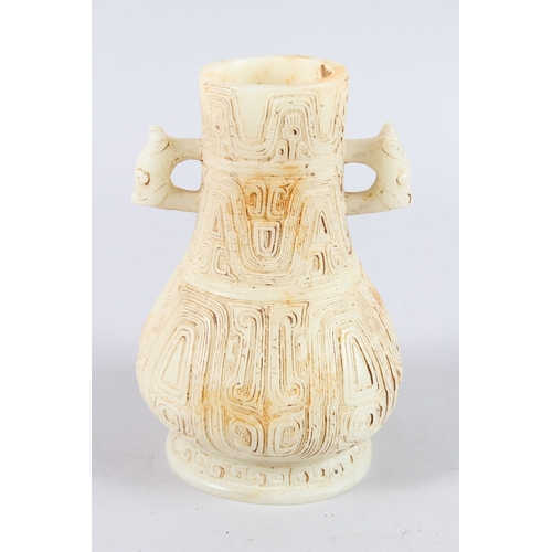 160 - A CHINESE ARCHAIC FORM CARVED JADEITE TWIN HANDLED VASE. 21cms high.