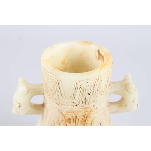 160 - A CHINESE ARCHAIC FORM CARVED JADEITE TWIN HANDLED VASE. 21cms high.
