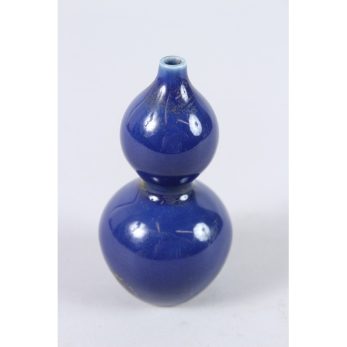 163 - A CHINESE PORCELAIN BLUE GROUND MINIATURE GOURD SHAPE VASE. 11cms high.