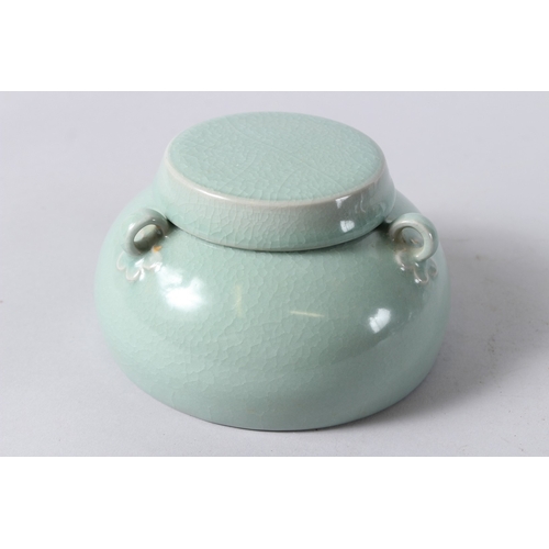 171 - A CHINESE CELADON GLAZED PORCELAIN BOWL AND COVER, with three loop handles. 15cms diameter.