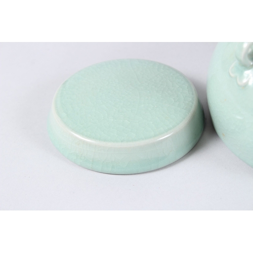 171 - A CHINESE CELADON GLAZED PORCELAIN BOWL AND COVER, with three loop handles. 15cms diameter.