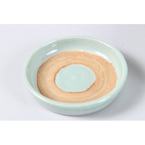 171 - A CHINESE CELADON GLAZED PORCELAIN BOWL AND COVER, with three loop handles. 15cms diameter.