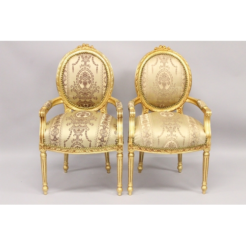 20 - A GOOD PAIR OF LOUIS XVI GILTWOOD ARMCHAIRS with padded oval backs and seats.