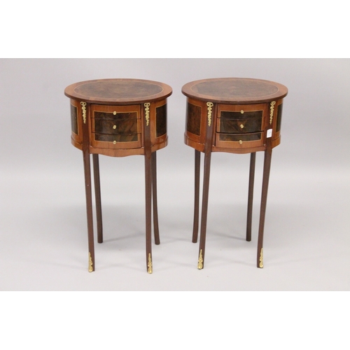 24 - A PAIR OF LOUIS XVI STYLE OVAL CROSSBANDED BEDSIDE TABLES with three drawers, on four curving legs. ... 