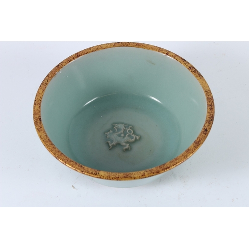 118 - A CHINESE CELADON BOWL with caring character to the base. 19cms diameter.