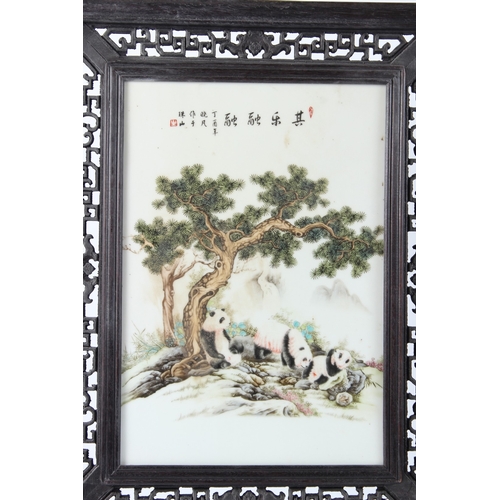 173 - A CHINESE PORCELAIN PANEL, 34cms x 24cms, painted with pandas, on a wooden stand. 65cms high.