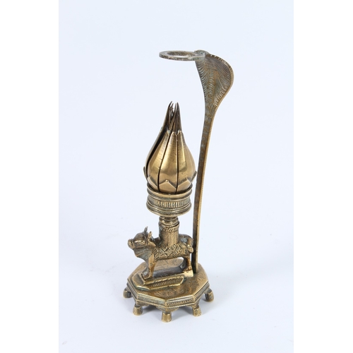 194 - A 19TH CENTURY INDIAN BRASS LOTUS LAMP , an animal holding a flower. 21cms high.