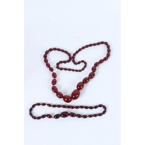 197 - TWO CHERRY AMBER BEAD NECKLACES. 80cms and 40cms long. 95grams.