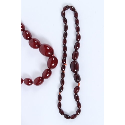 197 - TWO CHERRY AMBER BEAD NECKLACES. 80cms and 40cms long. 95grams.