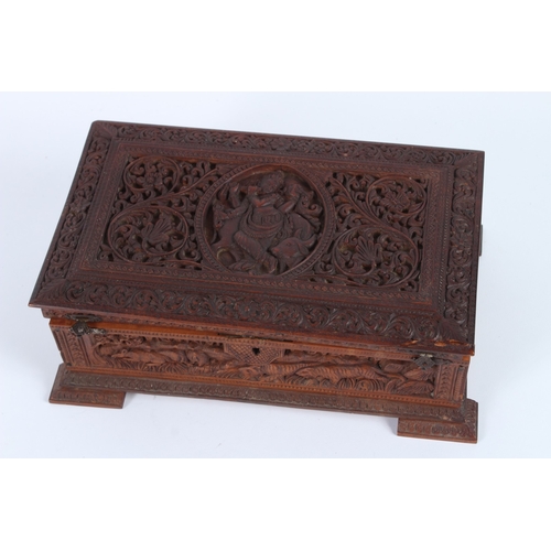 232 - A FINELY CARVED INDIAN SANDALWOOD BOX. 28cms long.