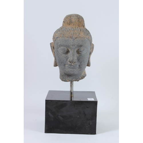 70 - A CARVED STONE HEAD OF BUDDHA from the GANDHARA REGION. 20cms high, on a marble base.
