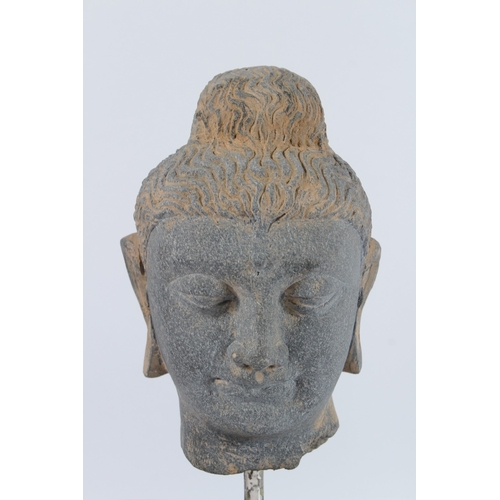 70 - A CARVED STONE HEAD OF BUDDHA from the GANDHARA REGION. 20cms high, on a marble base.