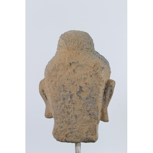 70 - A CARVED STONE HEAD OF BUDDHA from the GANDHARA REGION. 20cms high, on a marble base.