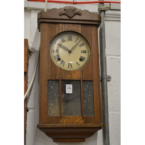 558 - An oak cased wall clock.