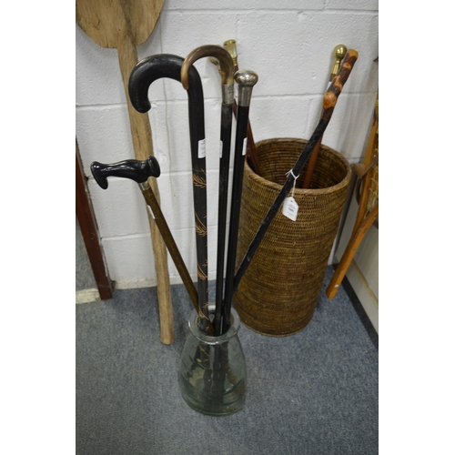 560 - Five various walking sticks in a glass jar/stick stand.