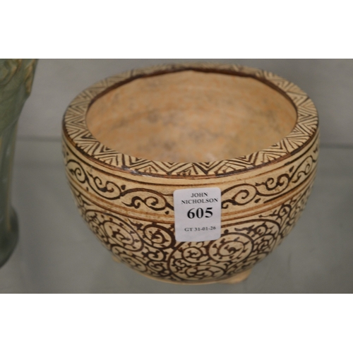 605 - A Chinese pottery bowl with scrolling decoration.