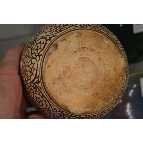 605 - A Chinese pottery bowl with scrolling decoration.