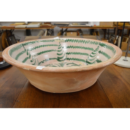 678 - A large terracotta bowl with slip glazed decoration.