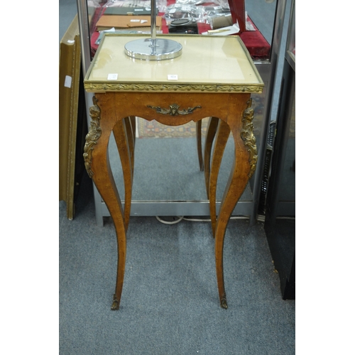 364 - A French style ormolu mounted birds eye maple gueridon with glass covered clothed top.