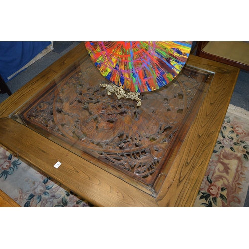 385 - A large square shaped Chinese elm coffee table, the central panel carved with dragons.