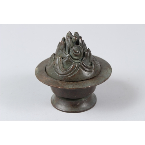 12 - A CHINESE BRONZE INCENSE BURNER. 10cms tall.  Under mark to the base.