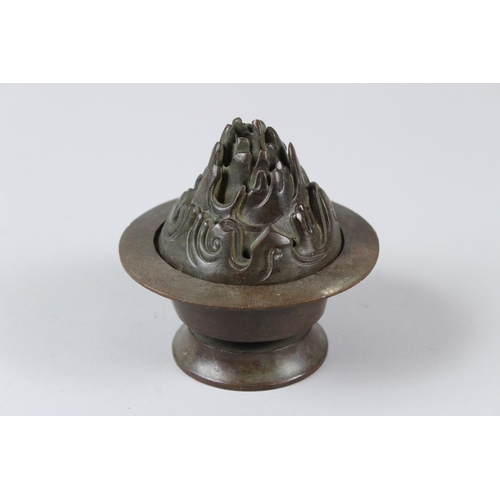 12 - A CHINESE BRONZE INCENSE BURNER. 10cms tall.  Under mark to the base.