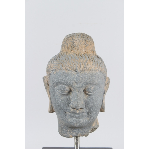 32 - A CARVED STONE HEAD OF BUDDHA from the GANDHARA REGION.  20cms high, on a marble base.