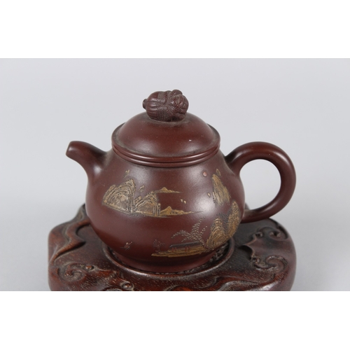 4 - A FINE CHINESE YIXING TEAPOT with hardwood stand.  12cms high.