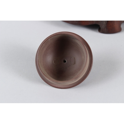 4 - A FINE CHINESE YIXING TEAPOT with hardwood stand.  12cms high.