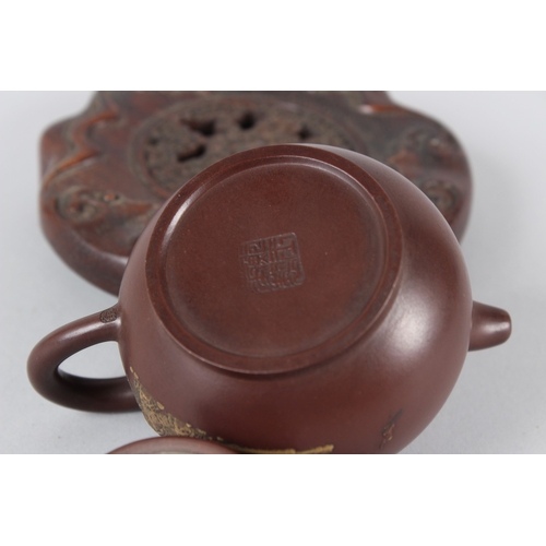 4 - A FINE CHINESE YIXING TEAPOT with hardwood stand.  12cms high.