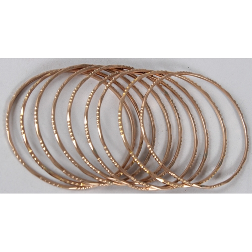 A SET OF NINE YELLOW METAL BANGLES. 55gms.