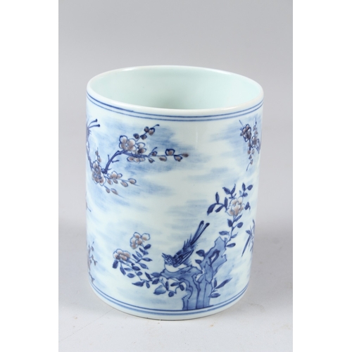 58 - A CHINESE BLUE AND WHITE BRUSH POT, painted with birds amongst prunus trees.  15cms high.