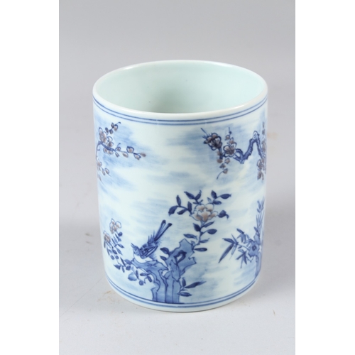 58 - A CHINESE BLUE AND WHITE BRUSH POT, painted with birds amongst prunus trees.  15cms high.