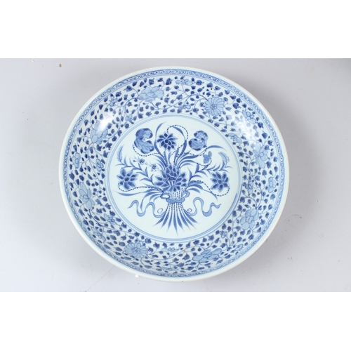 60 - A CHINESE BLUE AND WHITE CIRCULAR DISH, painted to the centre with a floral spray within a floral de... 