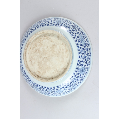 60 - A CHINESE BLUE AND WHITE CIRCULAR DISH, painted to the centre with a floral spray within a floral de... 