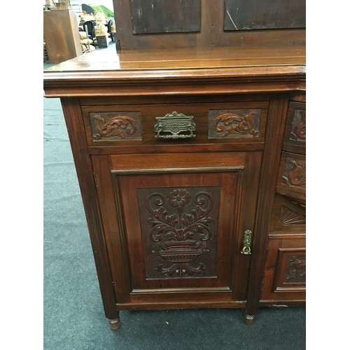 561 - An Edwardian oak carved sideboard with curved front.