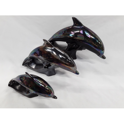 30 - Poole Pottery unusual set of three graduated dolphins with a metallic finish marked to base AL/GR.