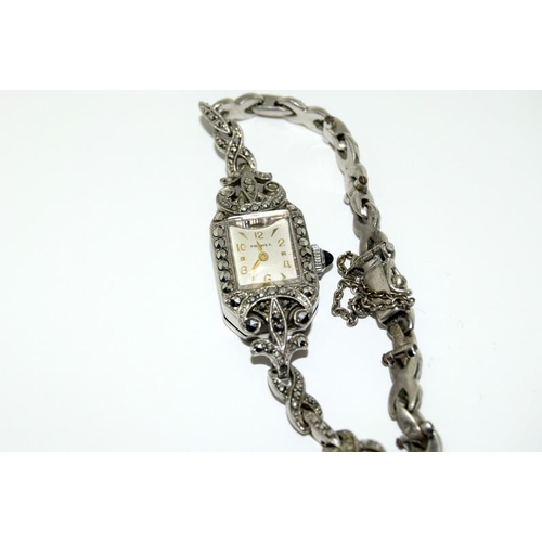 410 - A ladies silver & Marcasite watch with matching brooch.