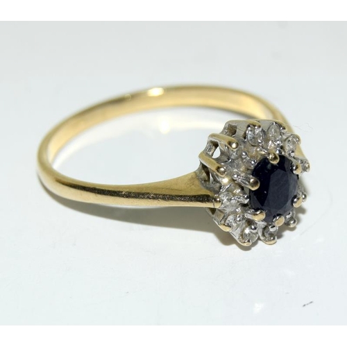 2320 - A 9ct gold ring with central sapphire enclosed with diamonds(Ref:17).