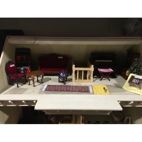 348 - Pink dolls house with a quantity of dolls house furniture, accessories and empty dolls furniture box... 